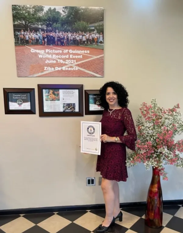 Ziba holding her Guinness certificate in her salon